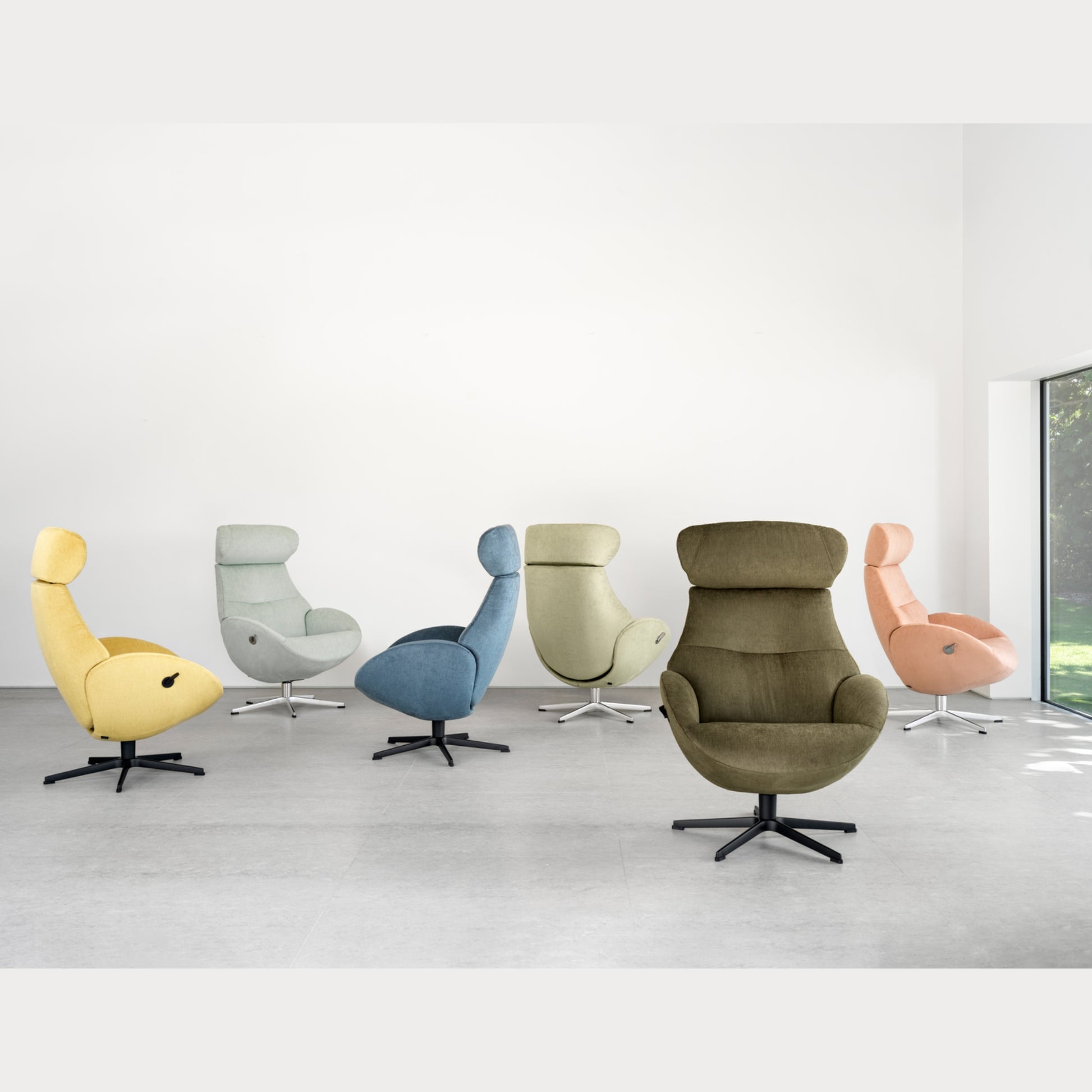 Set of six modern recliner chairs in various colors on a white floor with a light gray wall background.