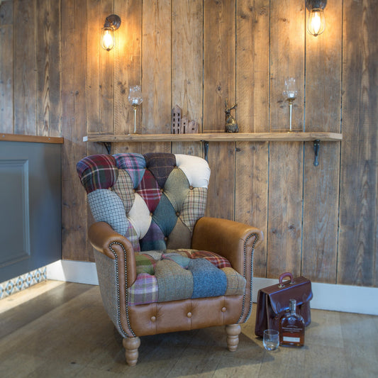 Patchwork armchair against a wooden wall with shelves and decorative items.