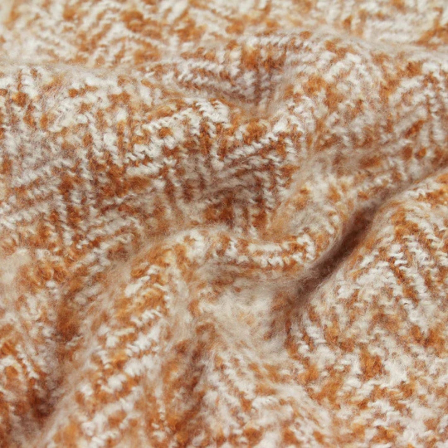 Close-up of a herringbone fabric surface in golden tones