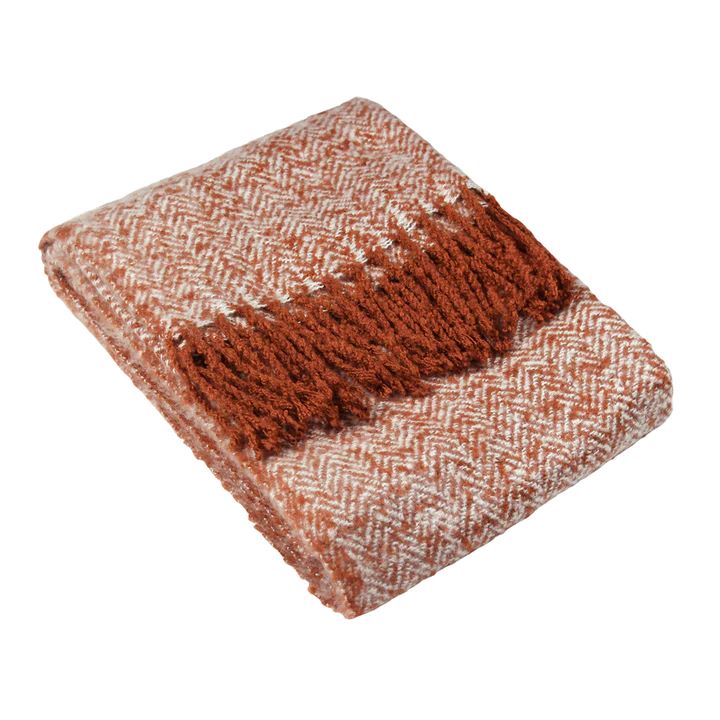 Heringbone rust fringed throw folded on a white background