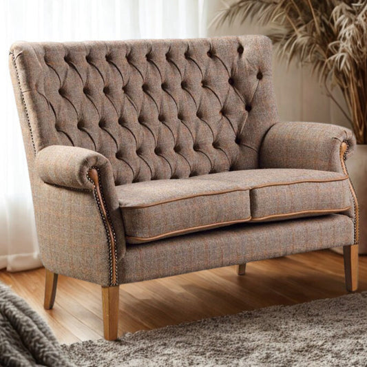 Brown tweed button back sofa in a room with wooden floor and plant