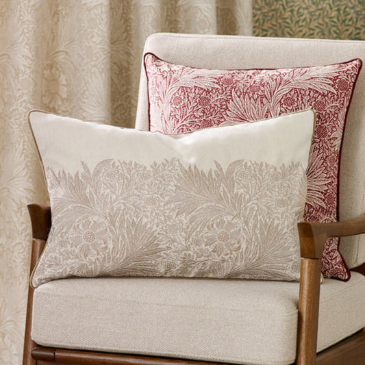 Decorative pillows with floral patterns on a chair against a neutral background