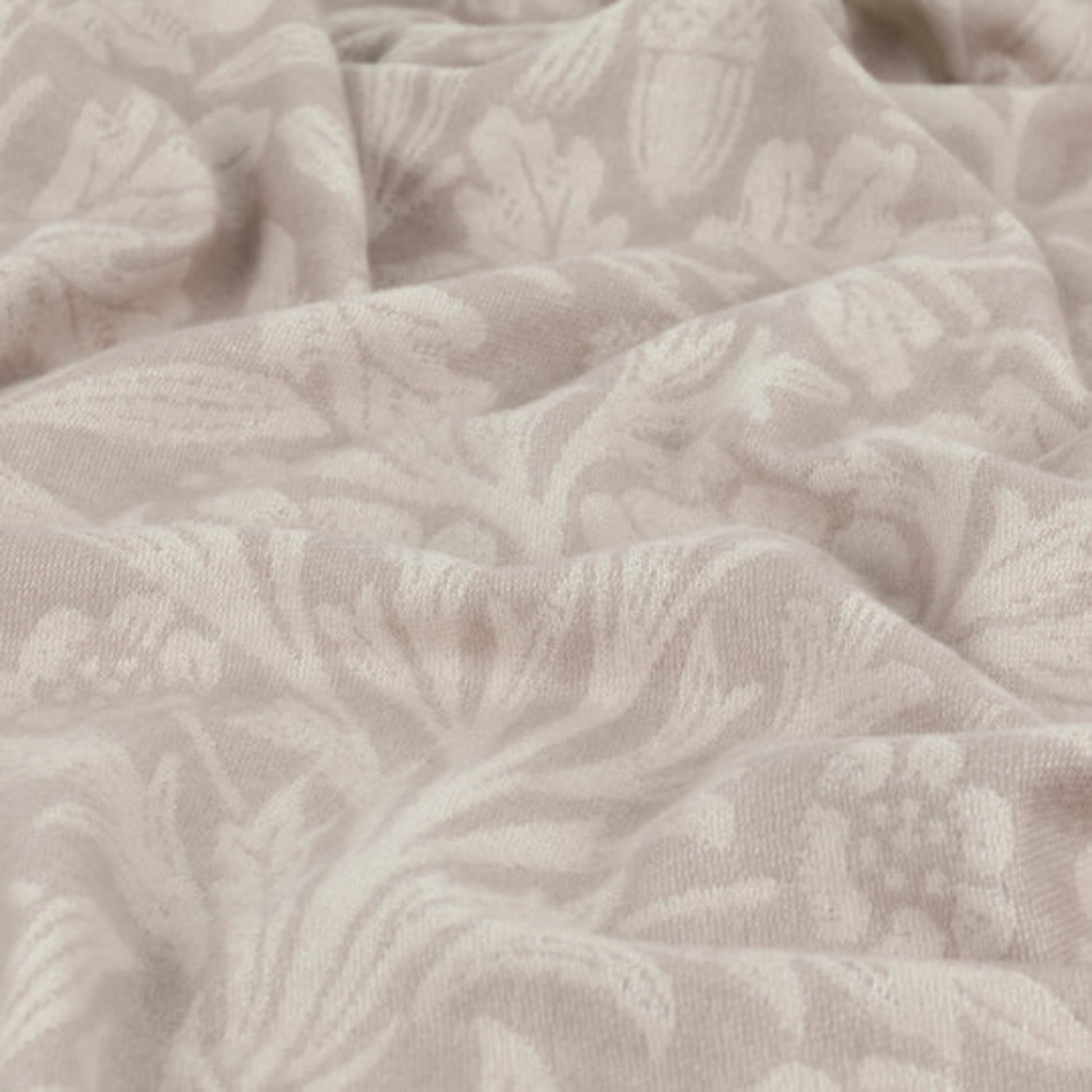 Close-up of textured beige fabric with a subtle pattern