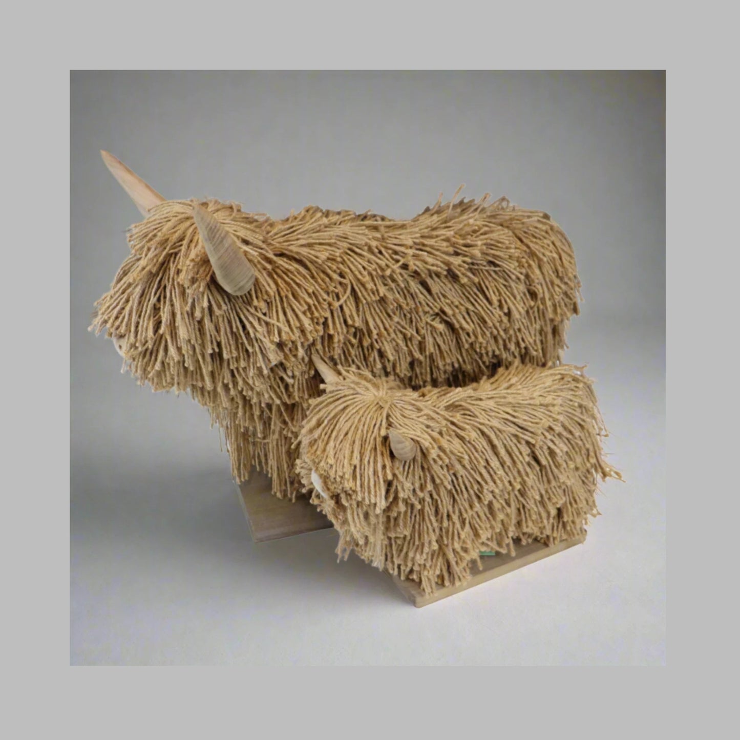 Wood and Jute sculpture of a stylized highland cows with frayed texture on a plain background