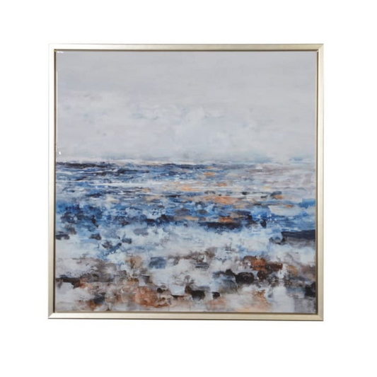 A framed abstract seascape painting with blue and natural tones, enclosed in a gold-colored frame.