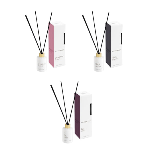 Three diffuser sets with reeds and boxes on a white background