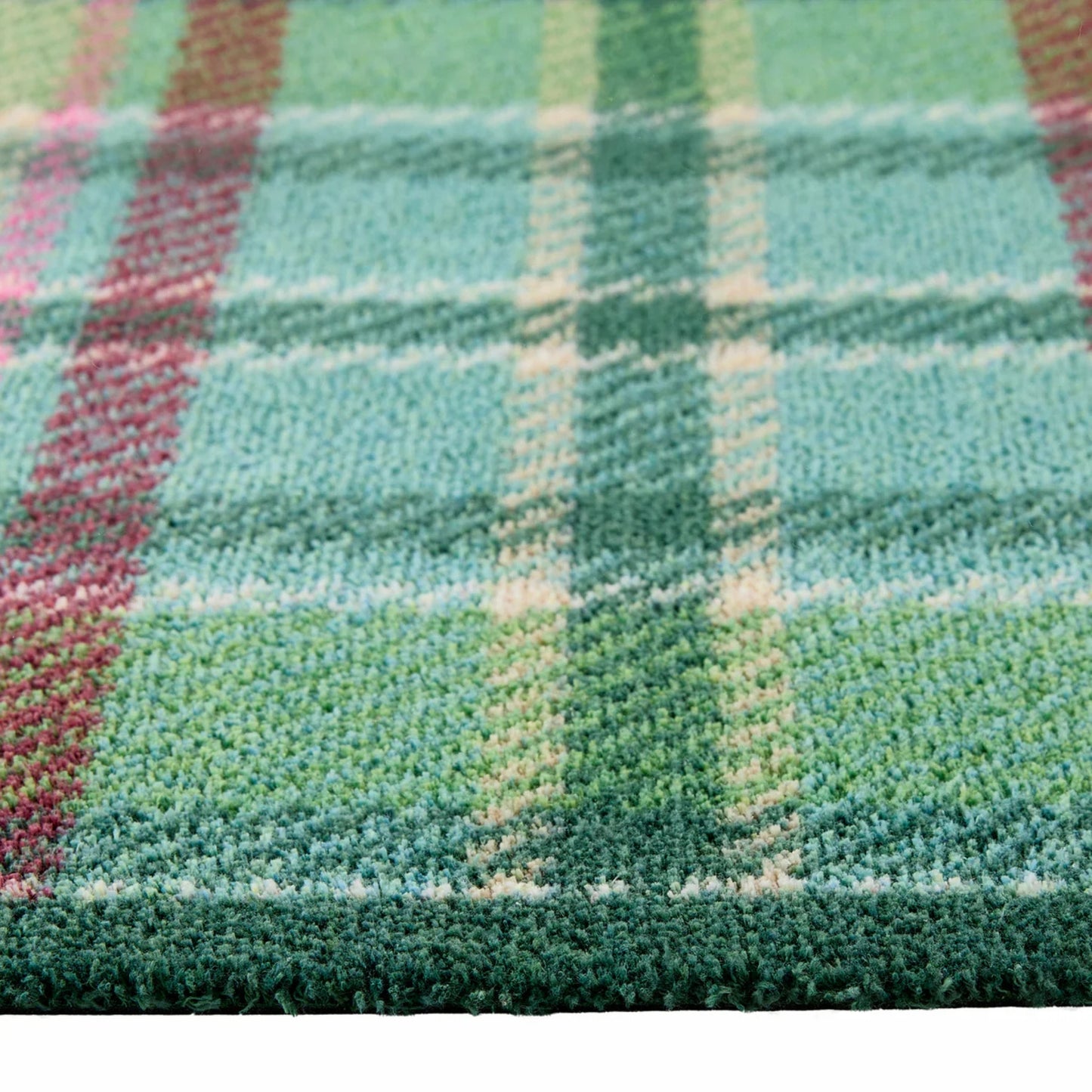 Close-up of a plaid fabric with green, pink, and blue colors.