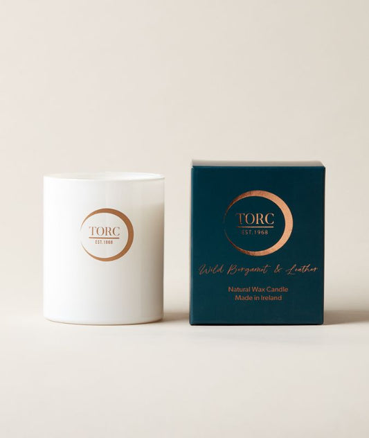 TORC candle and dark navy gift box packaging on a light beige background