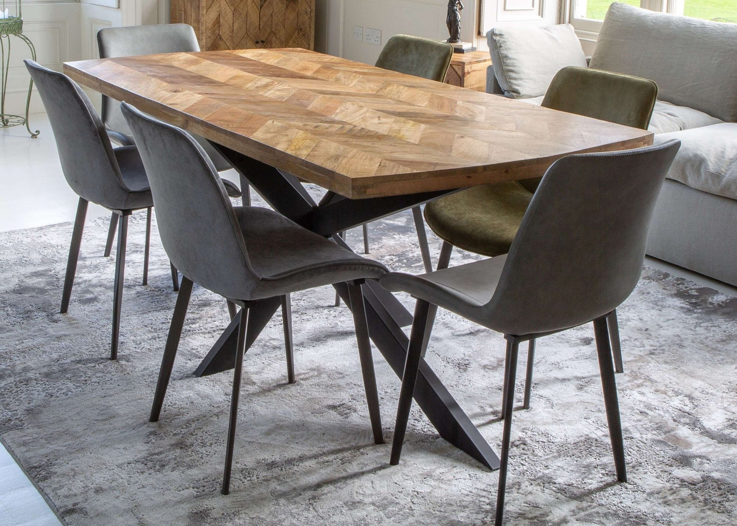 eva green and grey dining chairs around a wood dining table in front of a grey sofa