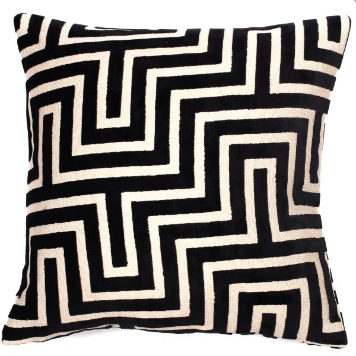A black and white geometric patterned velvet cushion.