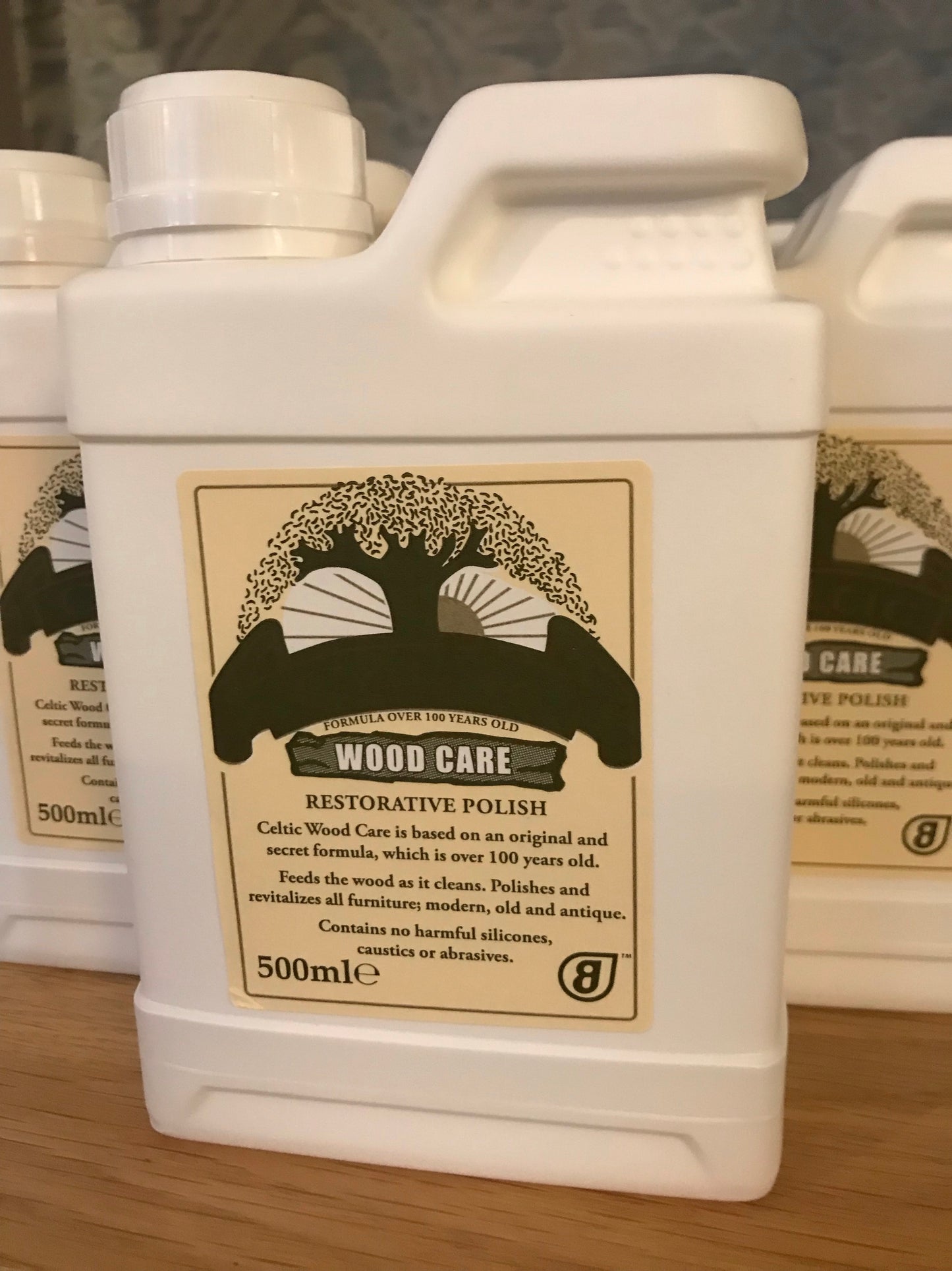 A bottle of Celtic Wood Care Furniture Polish with a white label and a black and gold design detail.