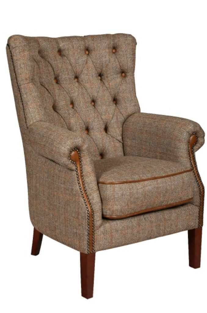A classic armchair with gently curving arms and deep buttoning, upholstered in brown Harris Tweed fabric.