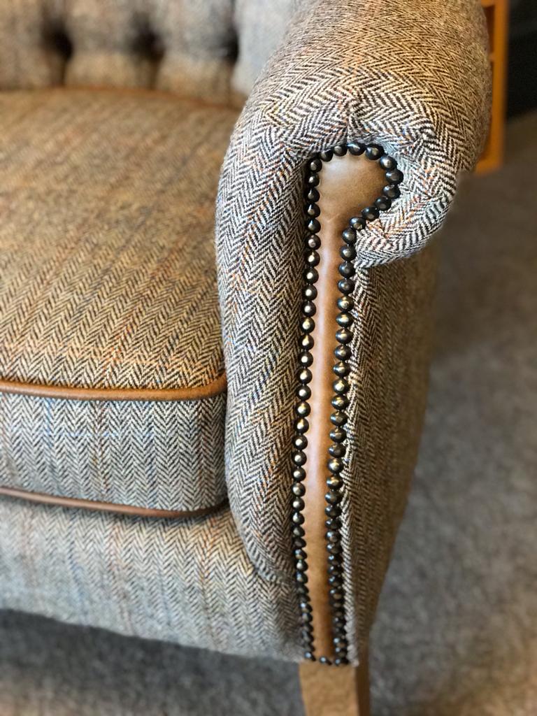 Arm detail showing leather and stud detail on a harris tweed armchair