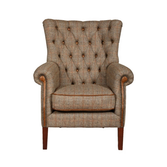 A classic armchair with gently curving arms and deep buttoning, upholstered in brown Harris Tweed fabric.