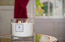 Christmas candle on a table in a room with a window and velvet red curtain