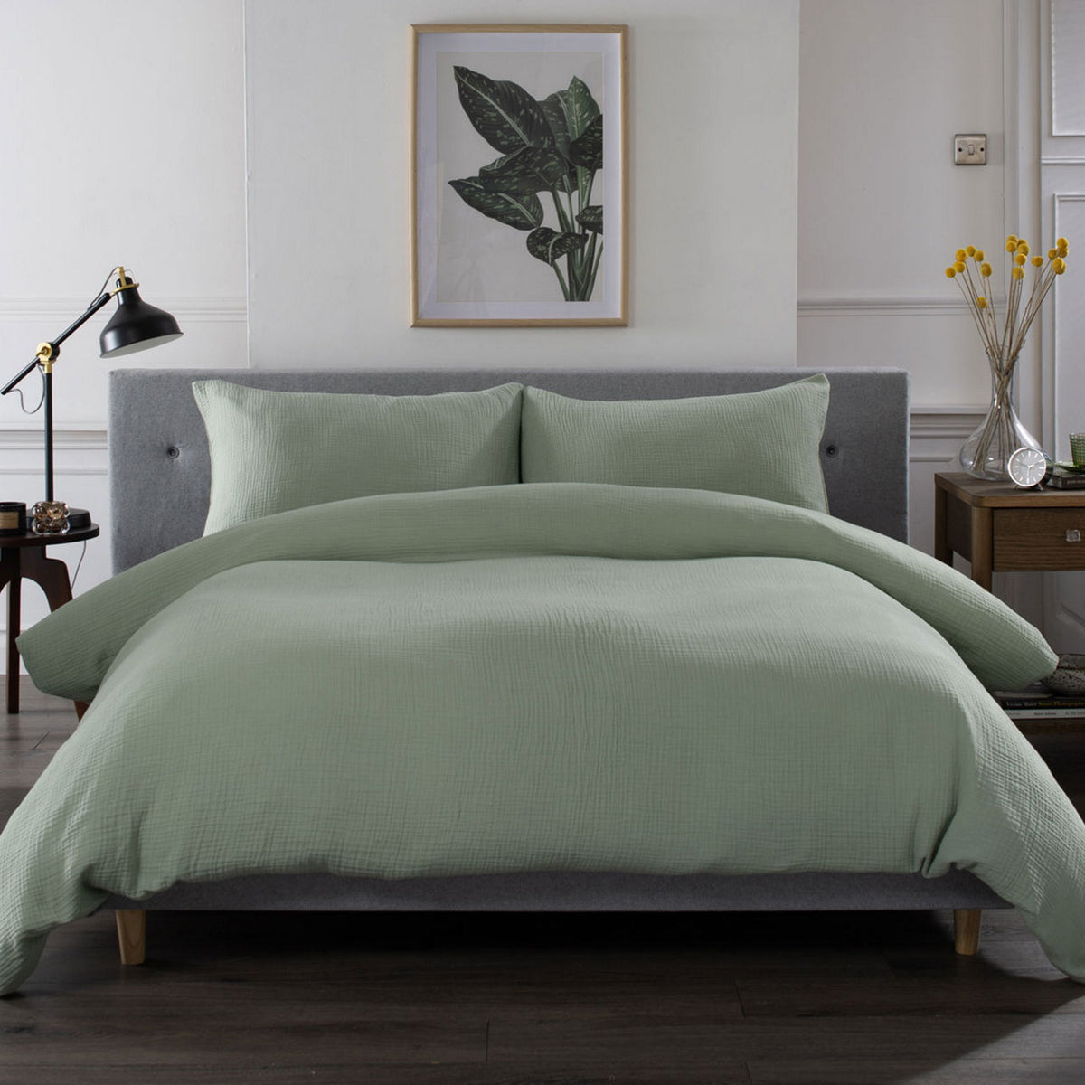 Sage green duvet cover set styled on a bed with matching pillowcases
