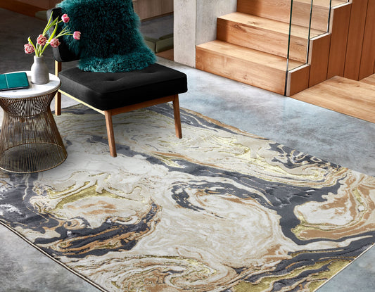 An abstract design area rug with metallic gold accents, placed on a floor in a room setting with a chair and side table.