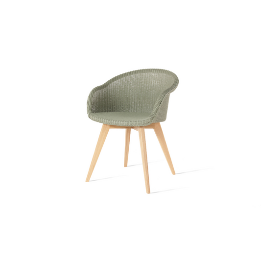 A dining chair with a green Lloyd Loom weave seat and an oak wood base.