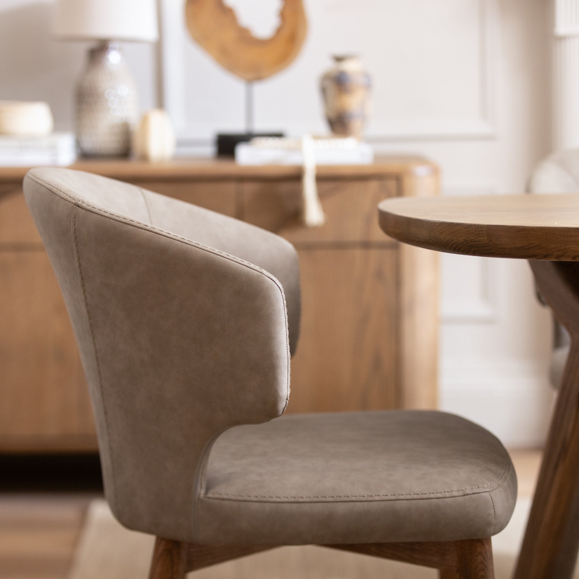 Beige chair in a room with wooden furniture and decor