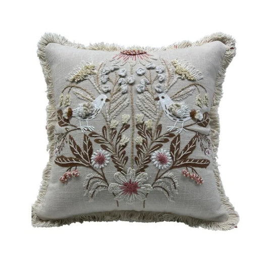 Decorative pillow with floral and bird embroidery on a white background
