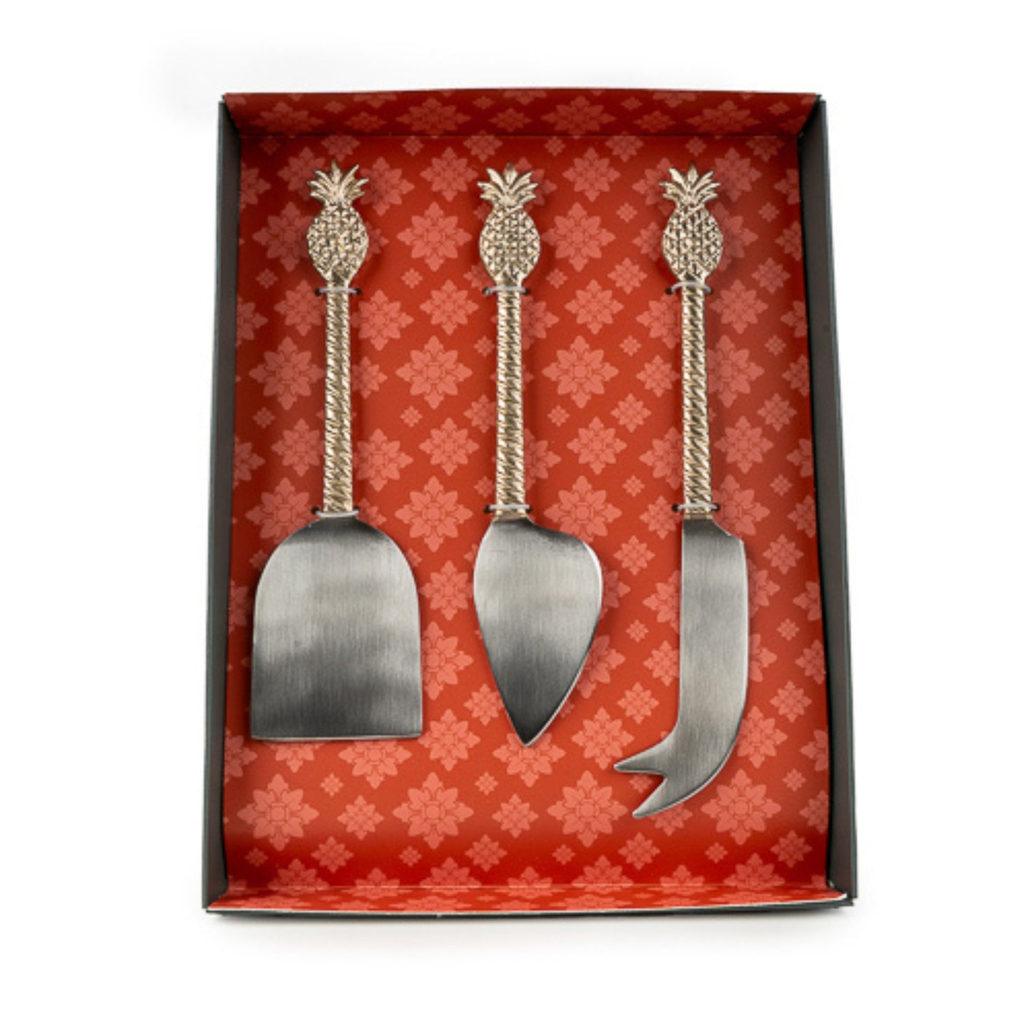 Set of three metal pineapple-themed cheese servers in a decorative box with a floral pattern.