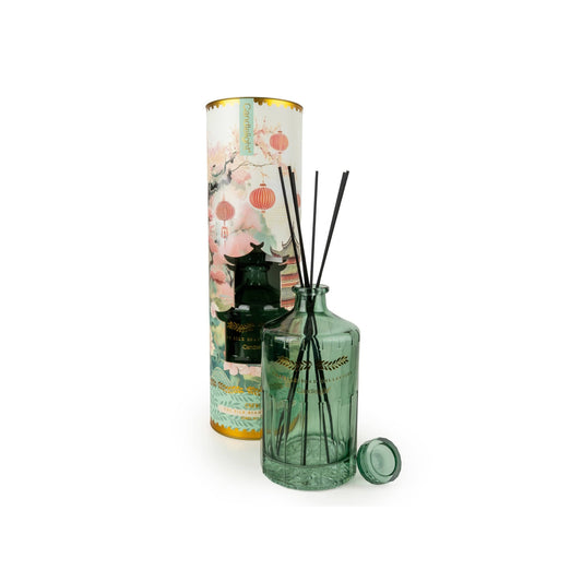 Green diffuser bottle with floral packaging on a white background
