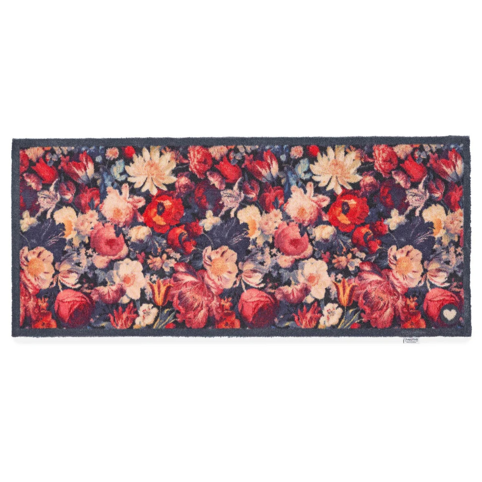 Floral patterned rug with red, pink, and cream flowers on a dark background