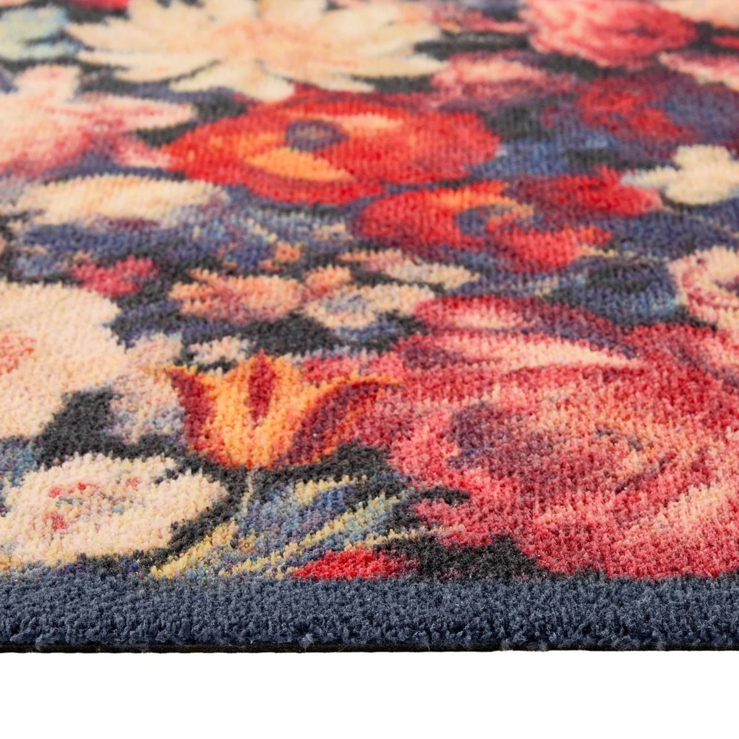 Close-up of a floral patterned rug with red, pink, and blue colors.