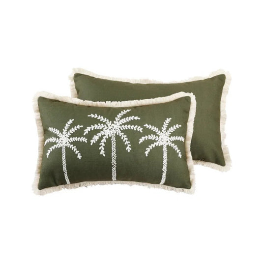 Two green pillows with white palm tree embroidery on a white background