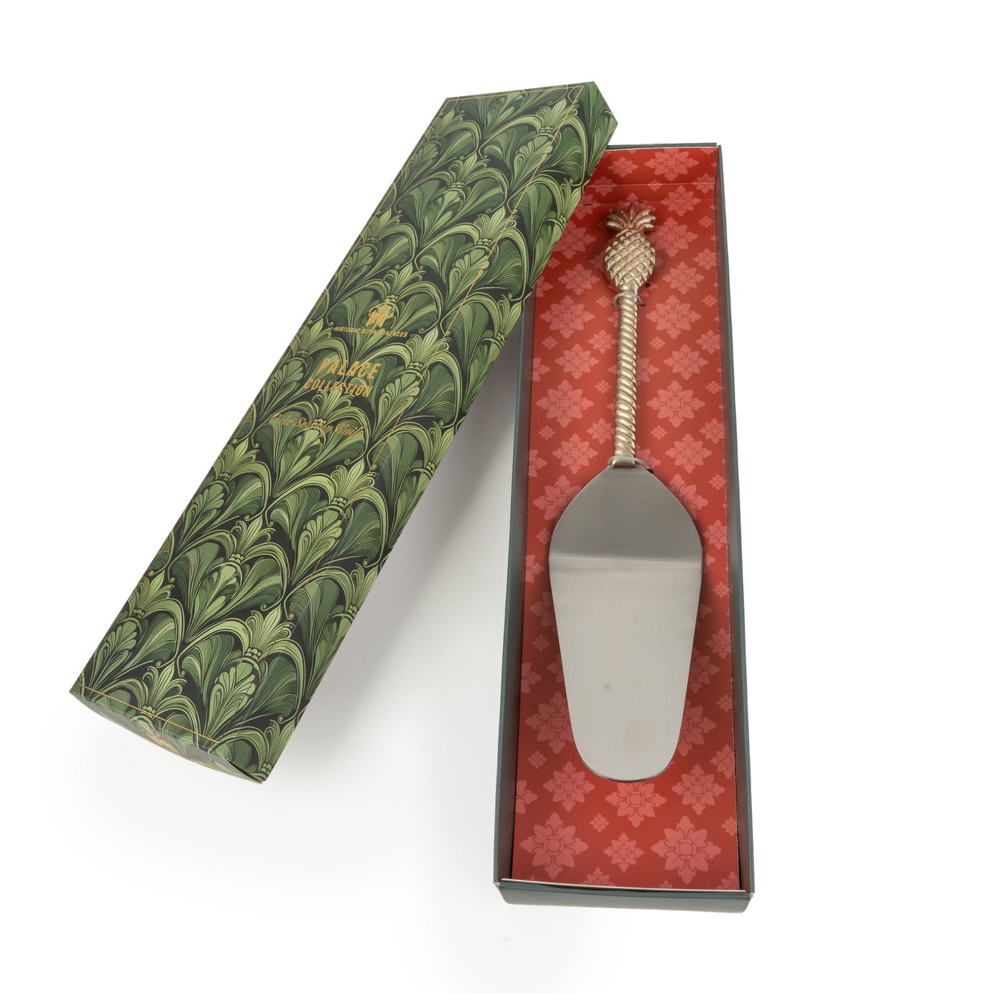 Silver cake server in a decorative box with green and red patterns