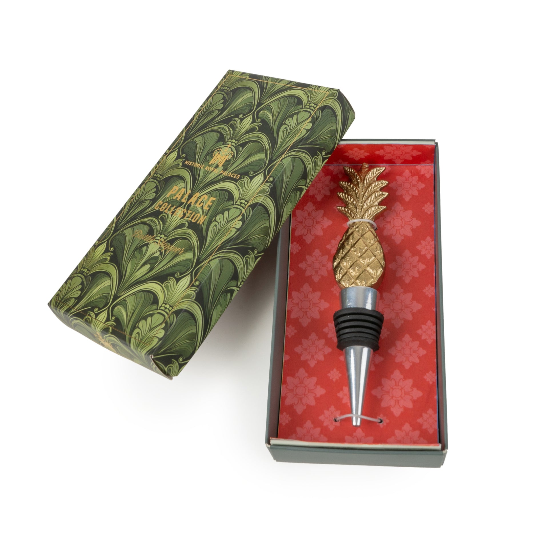 Pineapple-shaped bottle stopper in a decorative box with green and red design.