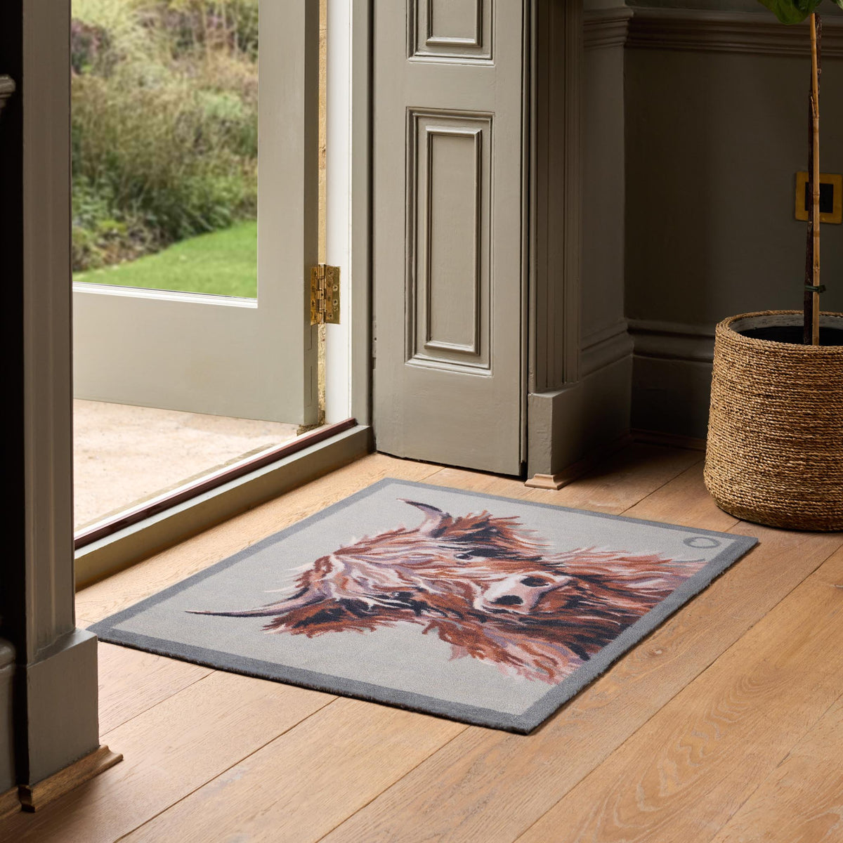 Heritage Highland Cow Hug Rug mat in a doorway