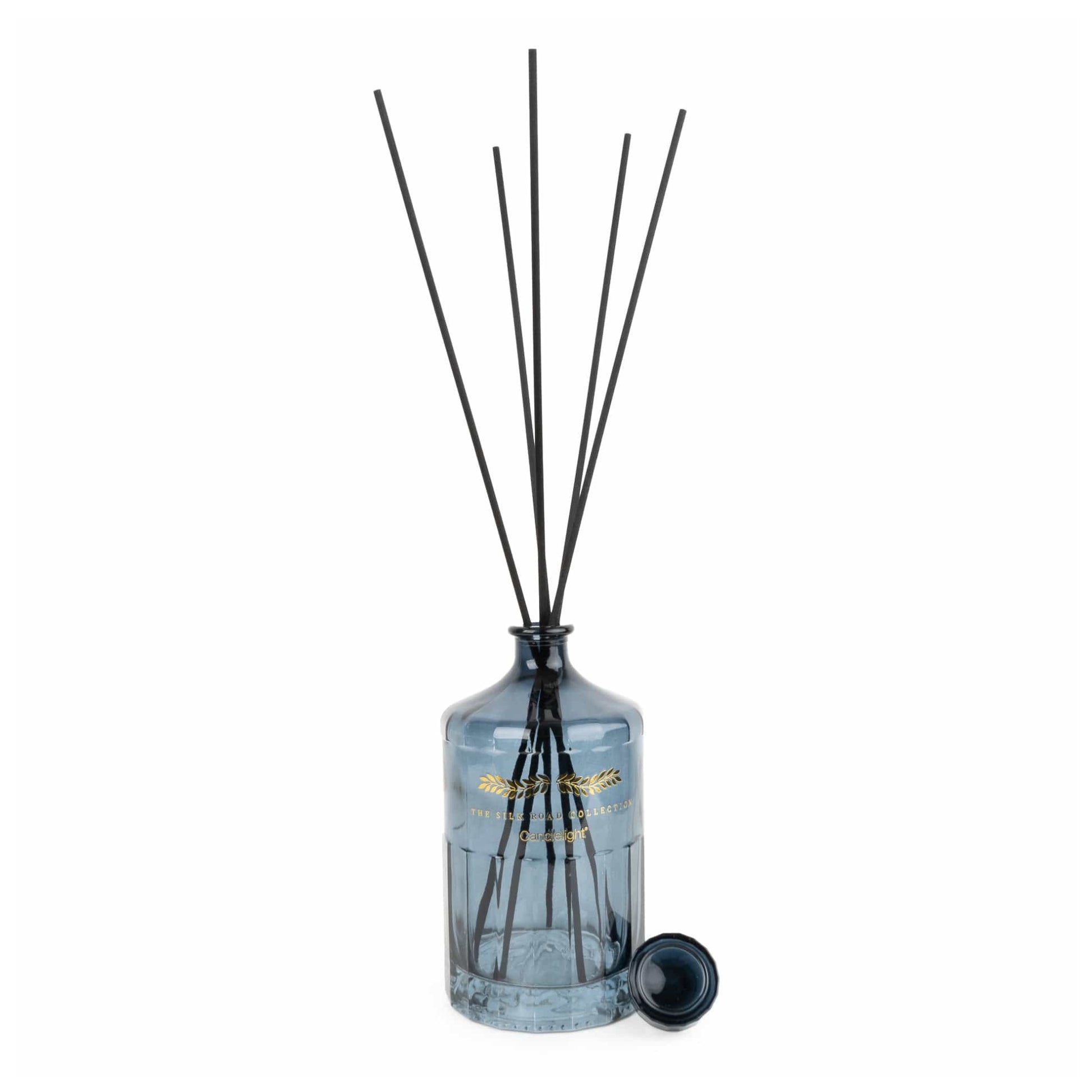 Diffuser with black sticks in a clear bottle on a white background