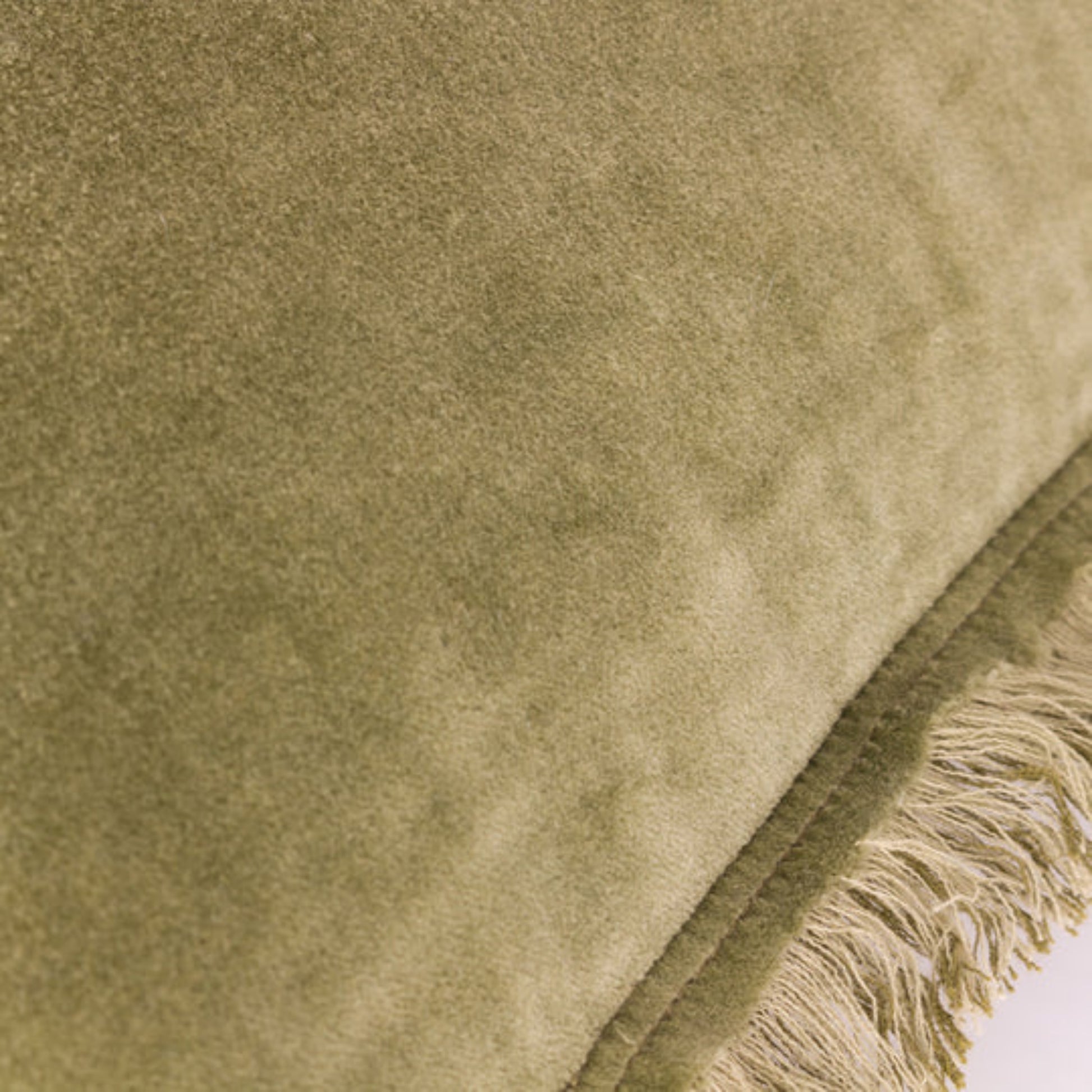 Close-up of a textured green fabric with fringes