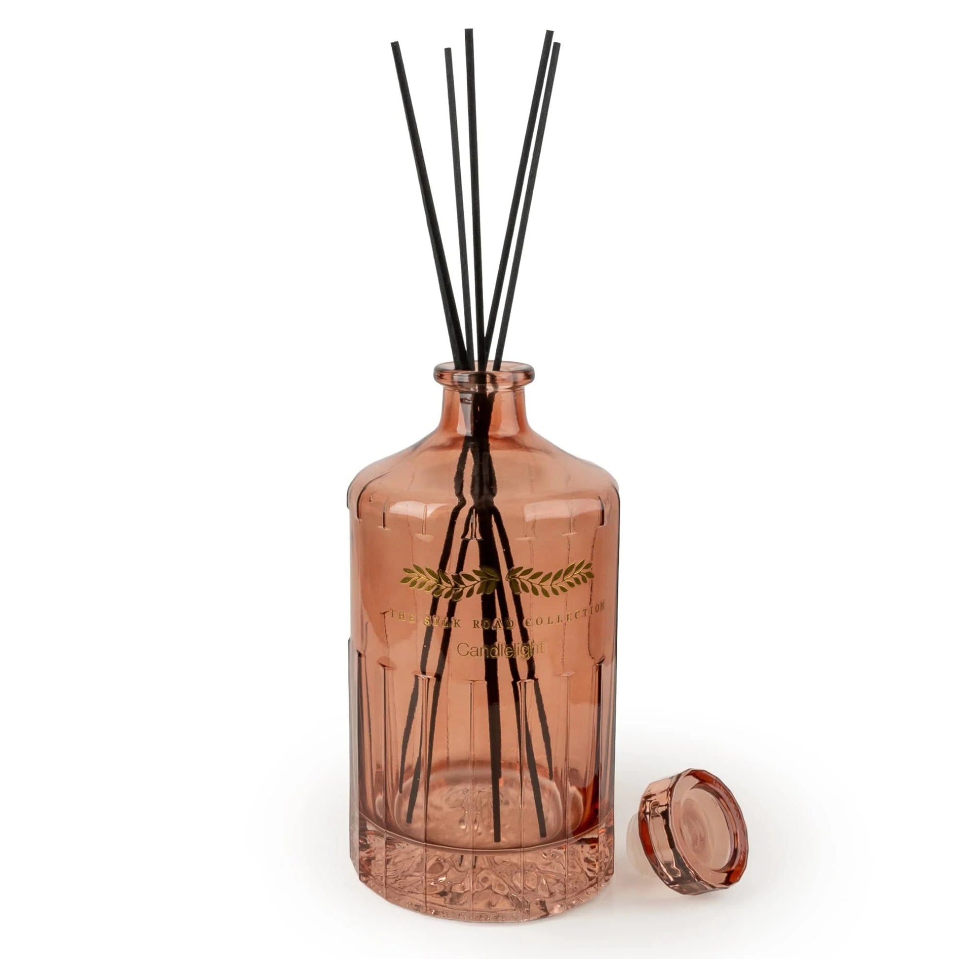 Pink diffuser bottle with black sticks on a white background
