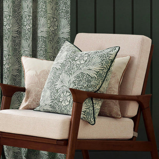 Green piped patterned cushion on a chair in a living room setting 