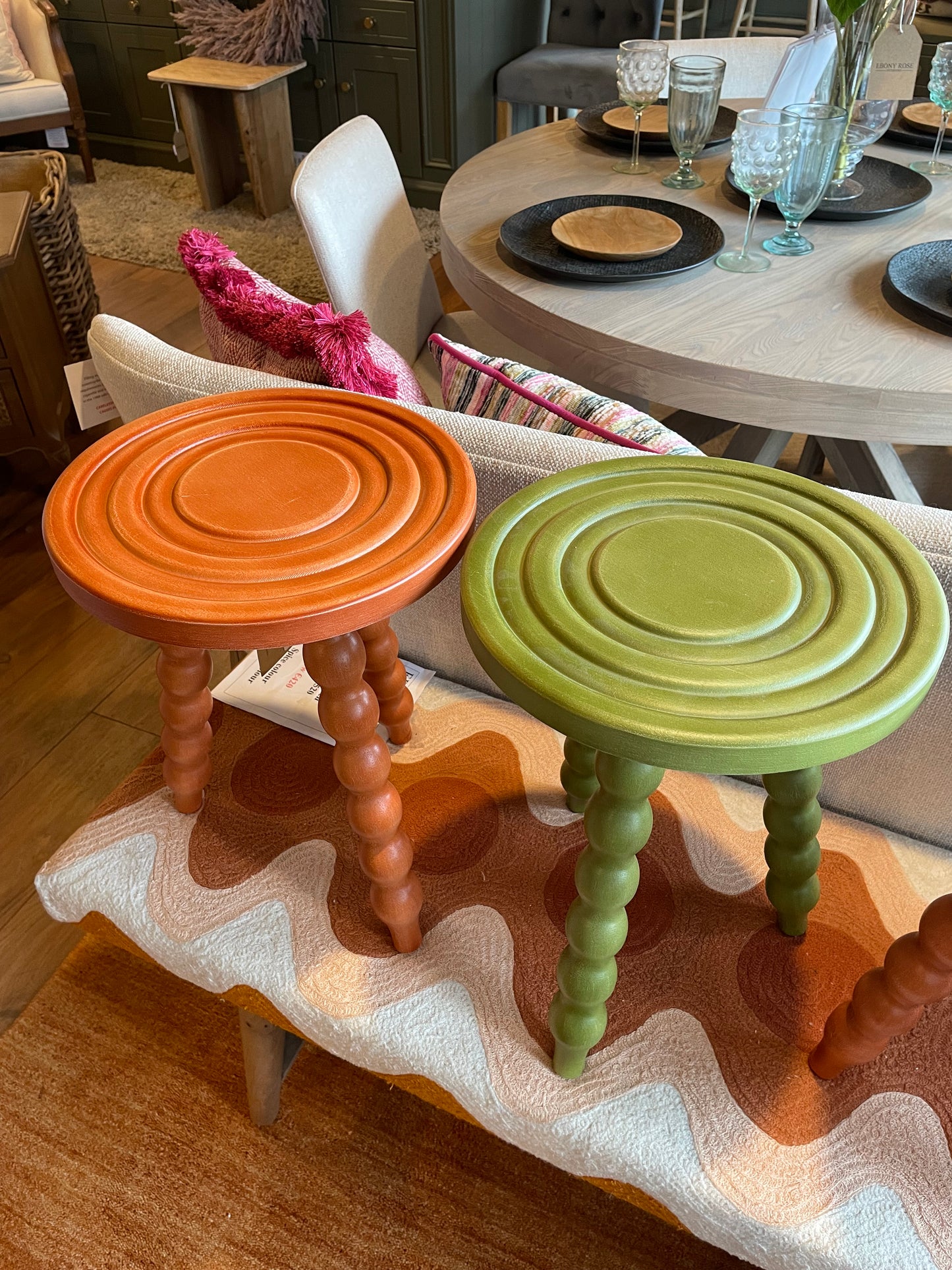 Colorful wooden stools on a textured surface with a blurred background