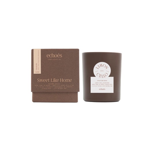 A tumbler candle with lid, labeled 'Sweet Like Home', next to its packaging box.