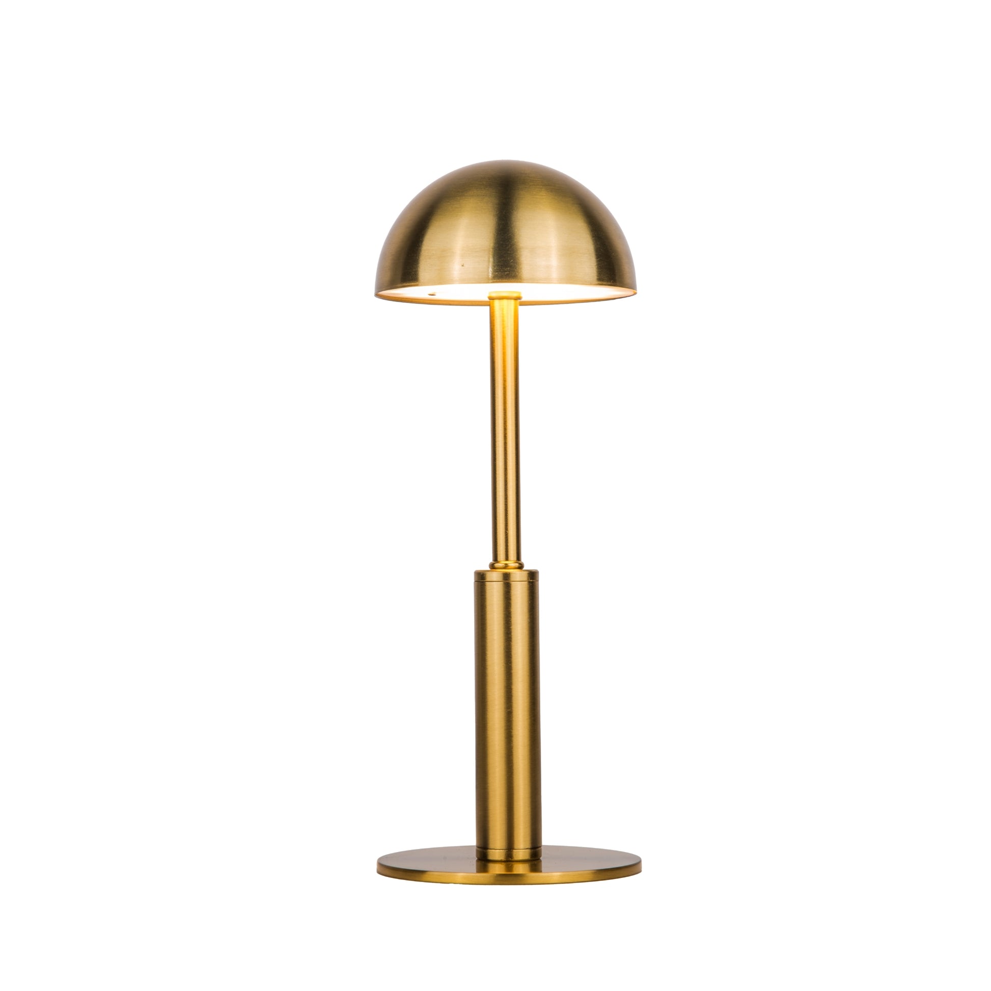 Lit Gold dome shaped metal table lamp on a white background