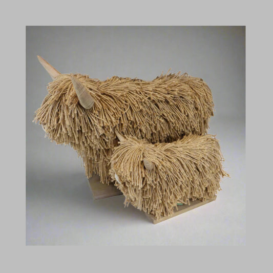 Wood and Jute sculpture of a stylized highland cows with frayed texture on a plain background