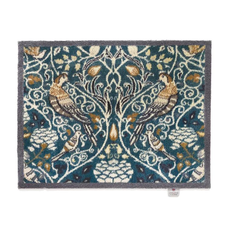 Hug Rug washable mat with a teal background featuring an intricate bird and foiliage design 