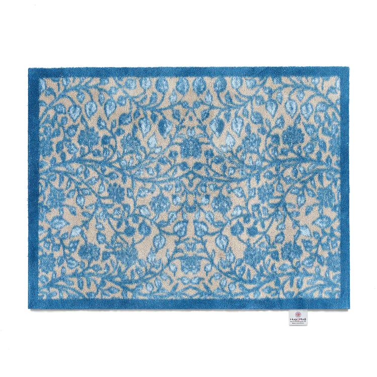 Washable Hug Rug mat with a blue floral trellis patterned design set on a neutral background