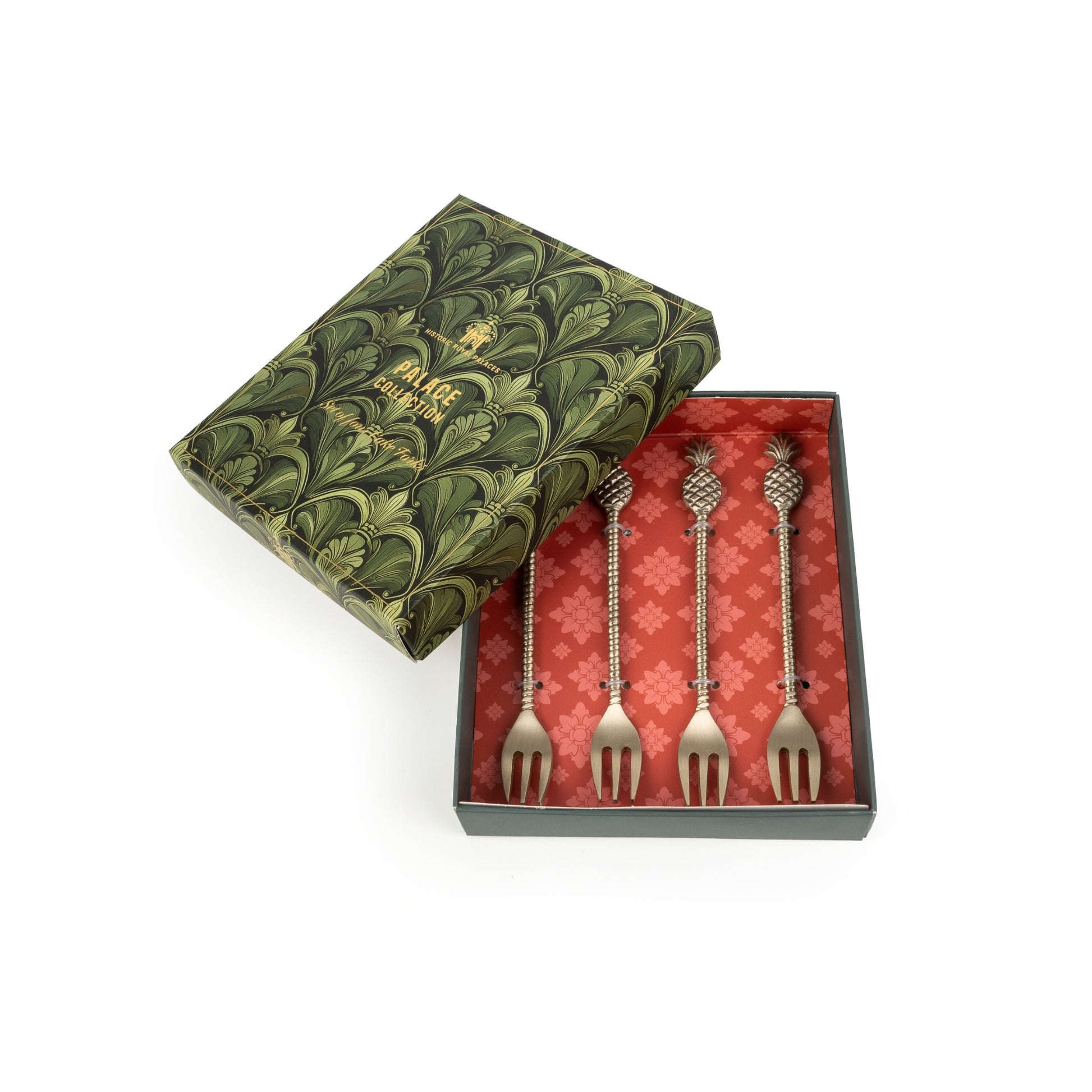 Set of four decorative forks in a patterned box with a green lid.