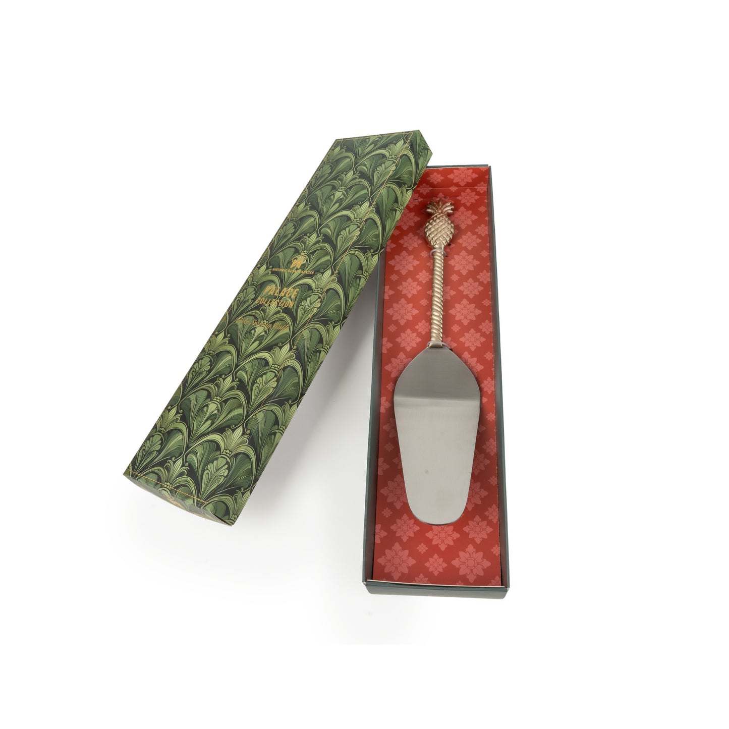 Metal cake server in a decorative box with green and red patterns