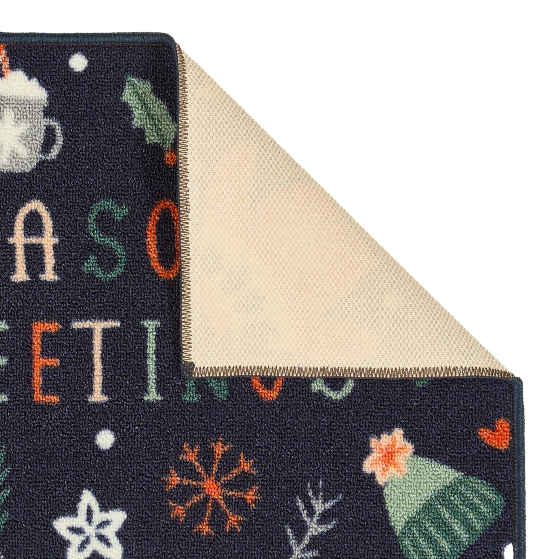 Close-up of a decorative rug with winter-themed patterns on a dark background.