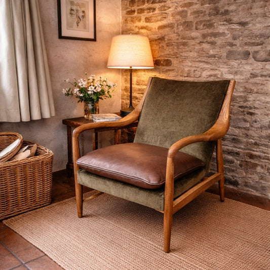 Cozy room with a wooden armchair, lamp, and decorative elements against a stone wall.