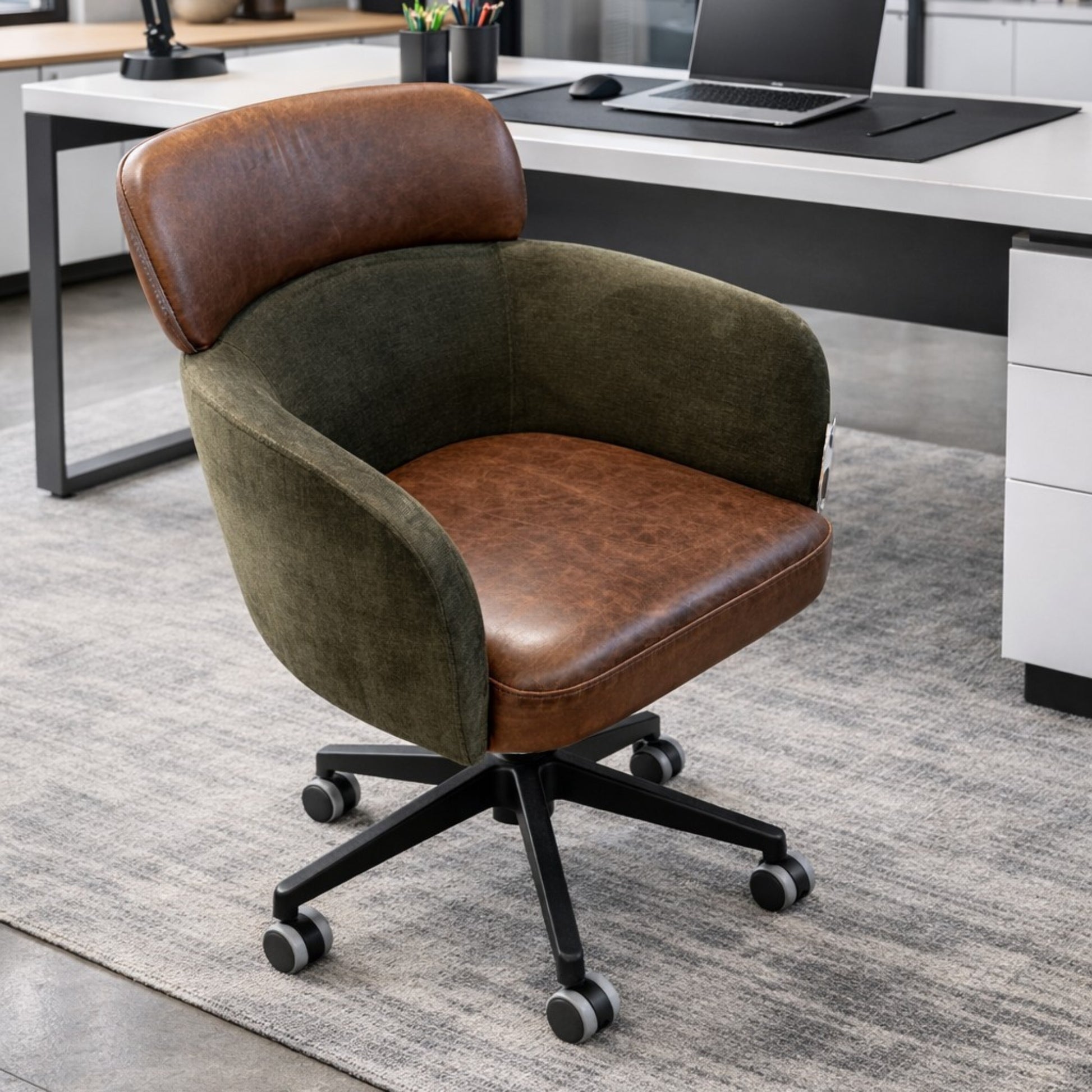 Leather and fabric curved office chair on castors in an office setting next to a desk