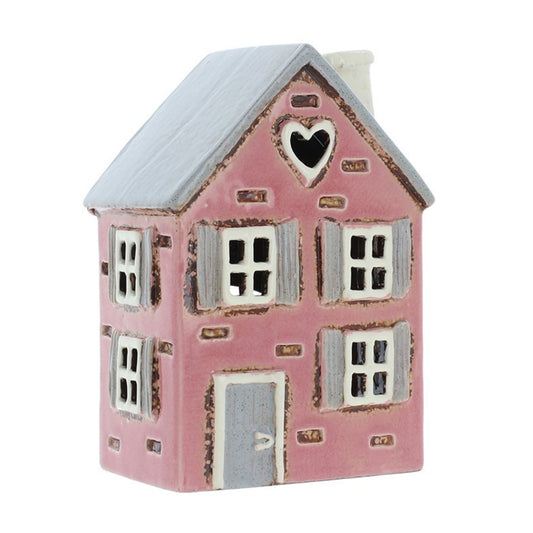 Pink ceramic house with a heart window on a white background