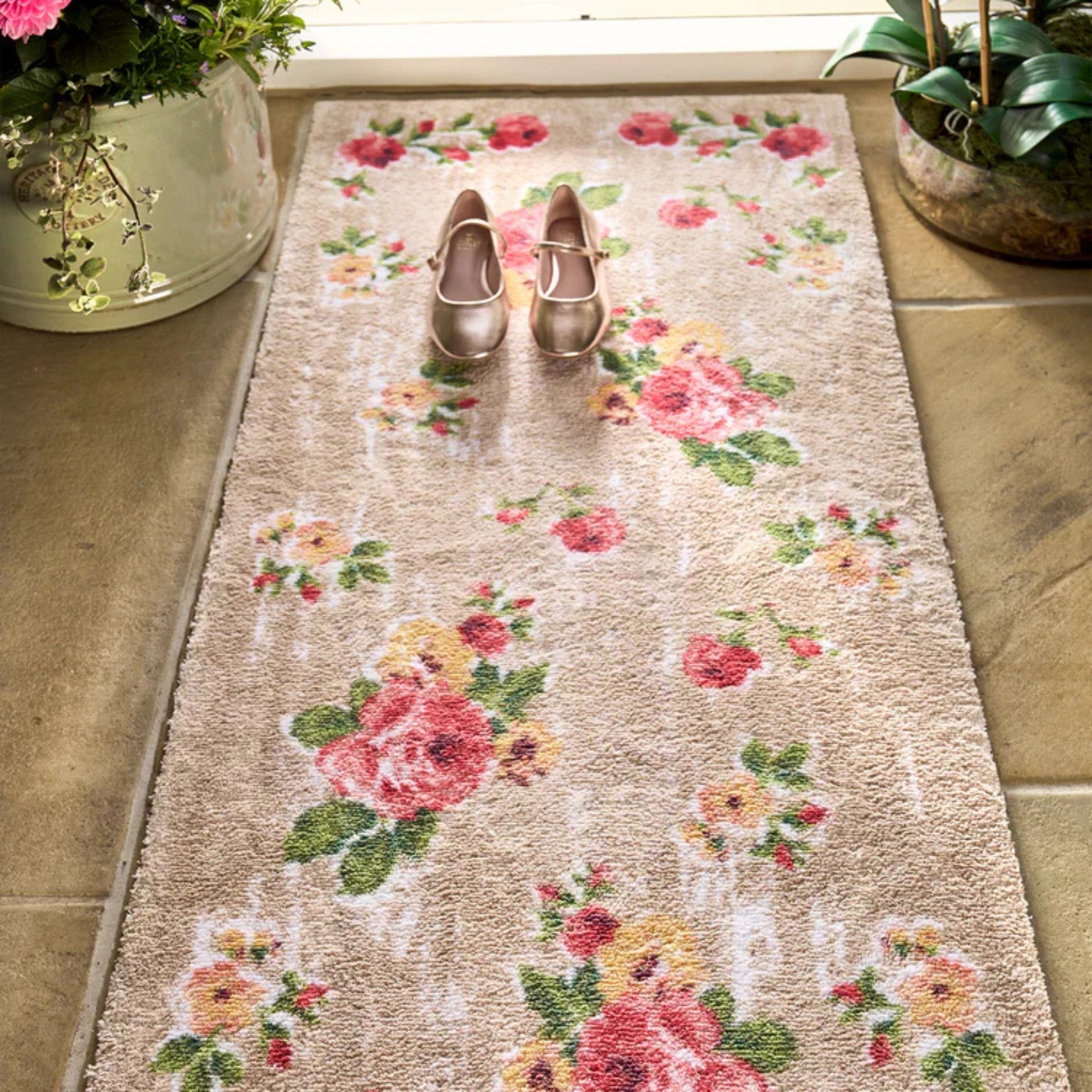 Floral patterned rug with two shoes on a tiled floor.