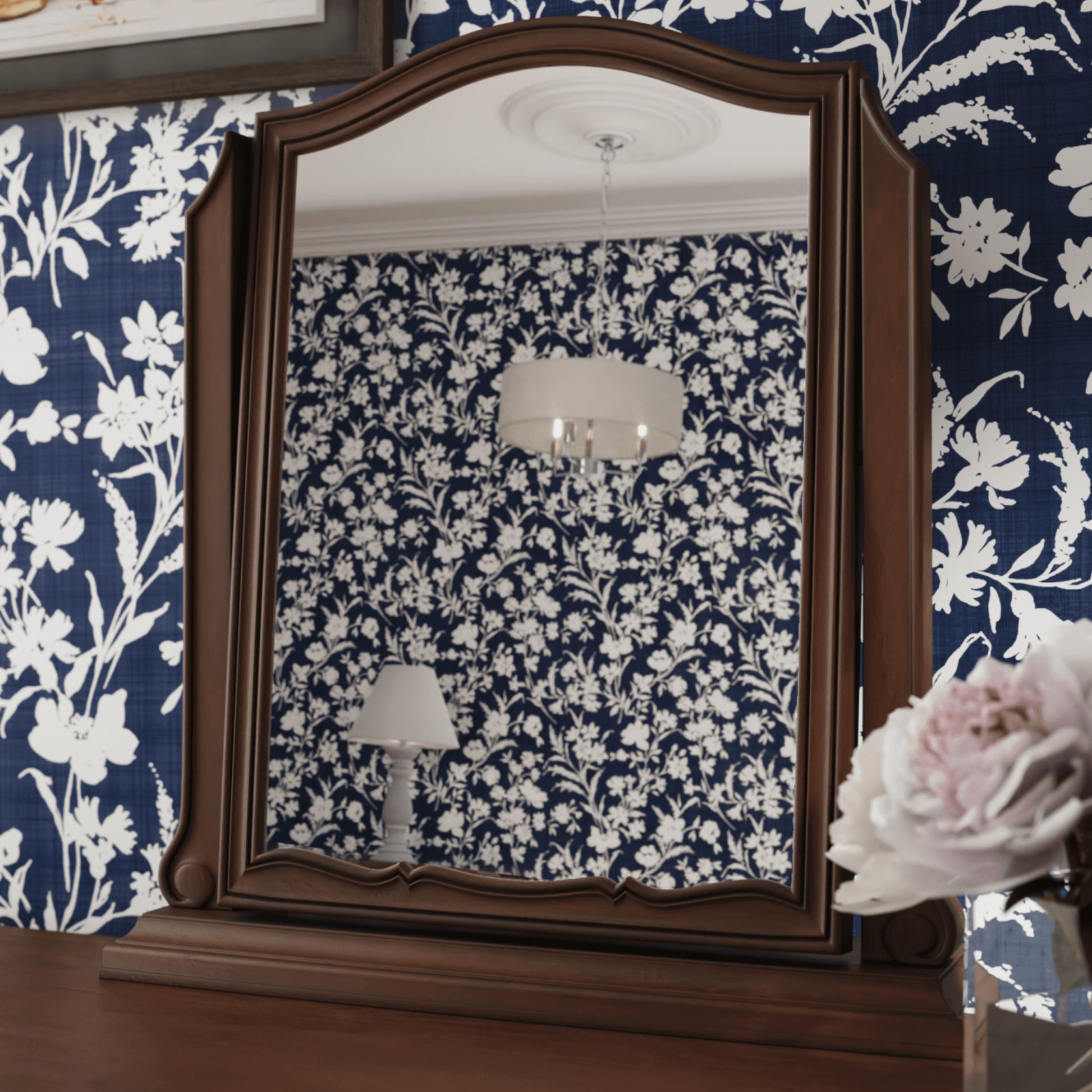 Walnut Vanity mirror on a walnut table with a navy and white floral background 
